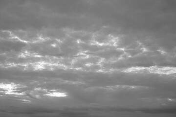 Grauer bedeckter Himmel am Abend mit etwas Sonne, die hindurch scheinen kann