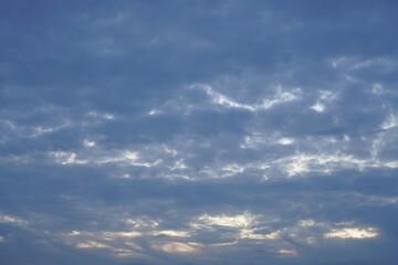 Obraz premium Bedeckter leichter blauer schöner Himmel am Abend mit etwas Sonne, die hindurch scheinen kann