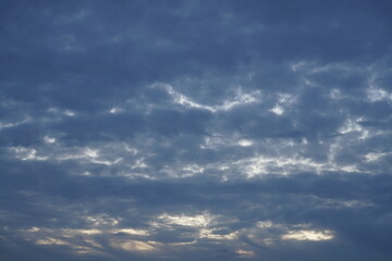 Bedeckter leichter blauer schöner Himmel am Abend mit etwas Sonne, die hindurch scheinen kann