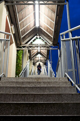 Illuminated staircase of apartment building. Steps at night. Low angle view. Person in the blur.