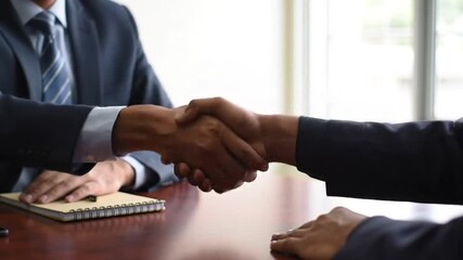 Happy young Indian business owner man shaking hands with male partner at meeting table, hiring new employee after interview,