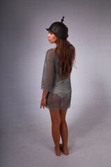 Slender barefoot warrior woman in chainmail and original medieval Asian helmet from back full...