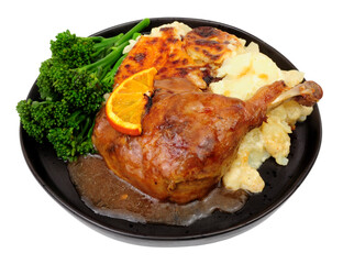 Roast duck leg with creamy dauphinoise potatoes, broccoli and orange sauce meal isolated on a white background