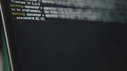 A close-up shot of a computer's command line interface. A blinking cursor and running text show a system process or script executing. Concept of hacking or software development. - Powered by Adobe