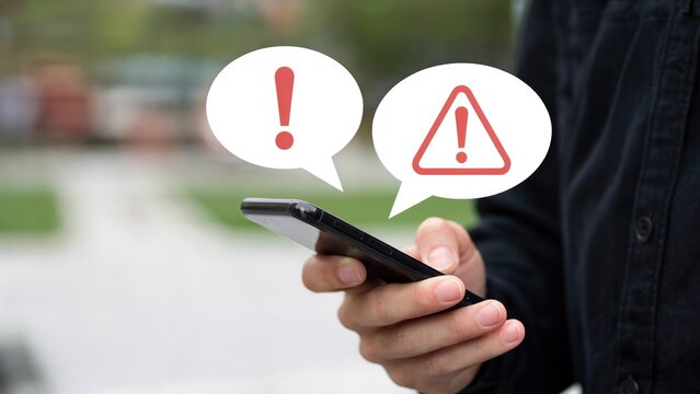 Urgent alert! Person receives critical notification on smartphone with warning icons in speech bubbles
