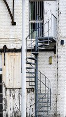 Old outdoor spiral staircase made of iron with vintage industrial atmosphere