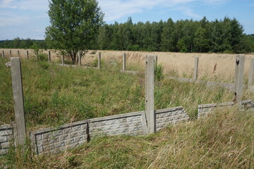 Devastated concrete fence in progress building in village.