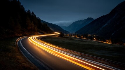 Nighttime mountain road with light trails and winding curves