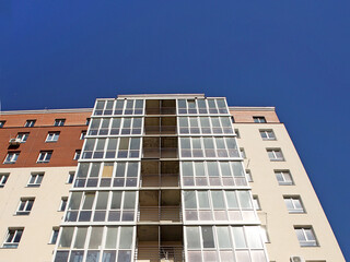 Lviv, Ukraine - 3 4 2020: Facade of a tall multi-storey modern house with balconies and large glass windows. Design of modern architecture. Top view from the bottom. Modern city architecture