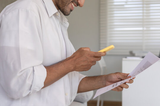 business man use phone to scan barcode or QR codes to pay credit card bill after receiving document invoice online. payment, receive, paying electricity, digital payments without money, technology