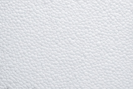 Closeup of white foam beads tightly fused in random pattern, creating durable packaging material texture ideal for industrial design