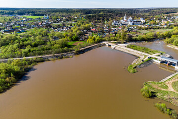 Fototapeta premium Aerial view of the dam on the Protva River and the Borovsko-Pafnutievsky Monastery. Borovsk, Russia
