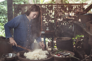 A young woman prepares sticky rice, a central part of a complete and balanced Isaan meal with...