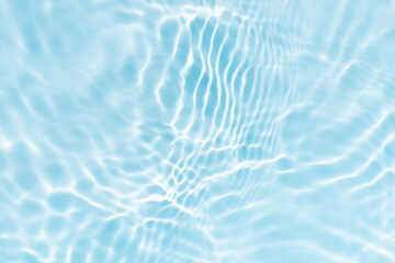 Blue water with ripples on the surface. Defocus blurred transparent blue colored clear calm water surface texture with splashes and bubbles. Water waves with shining pattern texture background.