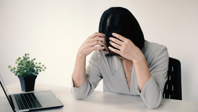 A beautiful office lady is tired from migraines while working, working too hard and stressed for work deadlines, and has office syndrome