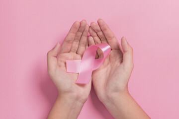 young girl hold pink ribbon breast cancer awareness. international Women Day and World Cancer Day. woman health check consciousness. sign cancer, health care, support patients, timely diagnosis
