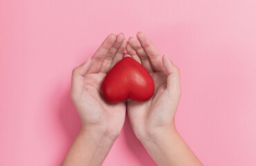 woman hands giving a red heart, red heart in young girl hands , health care, organ donation, family life insurance, world heart day, brain stroke. love concept.