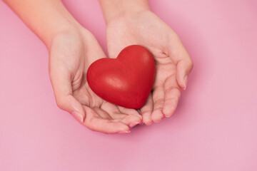 Obraz premium woman hands giving a red heart, red heart in young girl hands , health care, organ donation, family life insurance, world heart day, brain stroke. love concept.