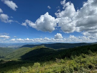 mountains and clouds Hiker standing on mountain ridge admiring panoramic view.