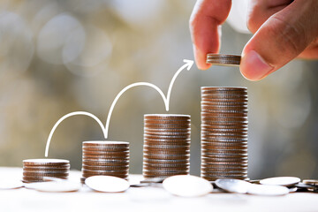 Man's hand put money coins to stack of coins with white arrow up. Financial, Business Growth...