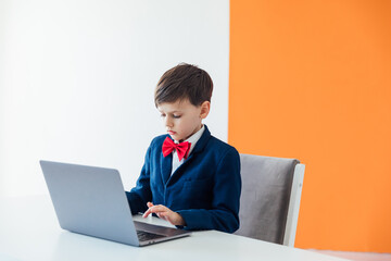 Little Boy In Business Suit And Tie Working On Laptop Online