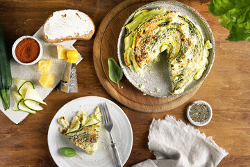 Vegetable zucchini round pie with pies on the ceramic plate on wooden background, top view