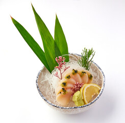 Freshly sliced scallop sashimi served on bed of shredded daikon radish with decorative leaves,...