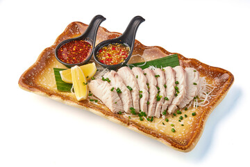 Steamed fish fillet served with spicy dipping sauce, garnished with fresh herbs and lemon wedges on decorative plate, offering vibrant and appetizing presentation