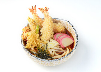 Bowl of Japanese tempura udon with thick noodles in savory broth, topped with crispy shrimp tempura, fish cakes, seaweed, green onions, and garnished with light, golden crunch