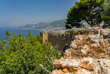Drone view of Alanya city, Turkey. Coastline, Mediterranean Sea, harbor, historic castle on the...