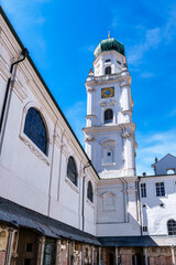 St. Stephans cathedral in Passau, Germany is an old white church with green metal domes on top of...