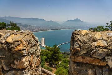 Drone view of Alanya city, Turkey. Coastline, Mediterranean Sea, harbor, historic castle on the...