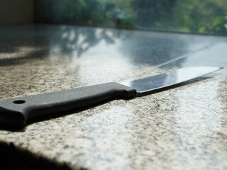 Professional chef's knife resting on a sleek granite countertop ready for culinary creations at home