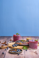 Summer table decorated with blueberries, strawberries, and a refreshing berry juice, ideal for hot days