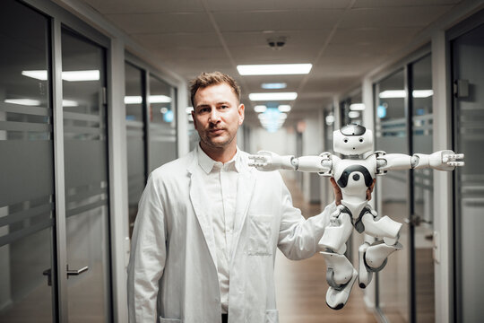 Doctor holding humanoid robot symbolizes AI and innovation in medicine