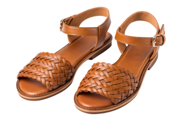 A pair of comfortable brown leather flat sandals featuring woven toe straps and adjustable ankle buckles is isolated on a transparent png background.