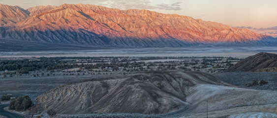 Camping site in desert landscape at sunset near mountains widescreen