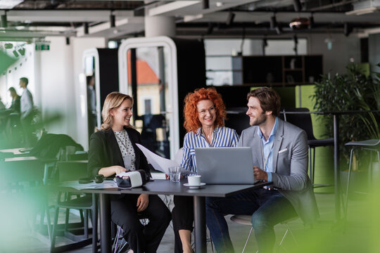 Creative team having discussion over coffee about project strategy.
