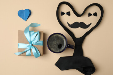 Father's Day. composition with gift box, glasses, cup of coffee and tie on beige background.
