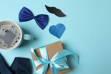 Father's Day. composition with gift box, glasses, cup of coffee and tie on blue background.
