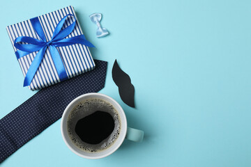 Father's Day. composition with gift box, glasses, cup of coffee and tie on blue background.
