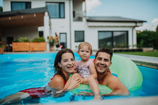 Happy family enjoying summer at pool