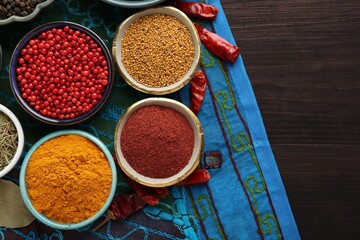 Different aromatic spices on wooden table, flat lay. Space for text