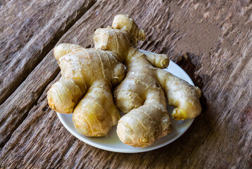 Ginger in dish on old wooden table background