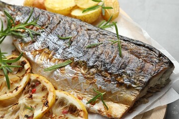 Tasty roasted mackerel with spices and potatoes on grey table, closeup. Homemade seafood dish