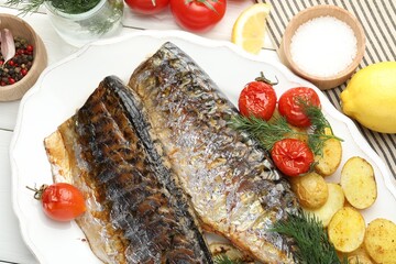 Tasty roasted mackerels with spices, tomatoes and potatoes on white wooden table, flat lay. Homemade seafood dish