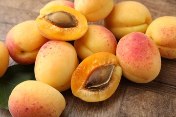 Many fresh apricots on wooden table, closeup