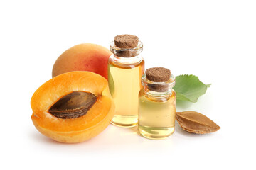Bottles of essential oil, fresh apricots, kernel and green leaf isolated on white