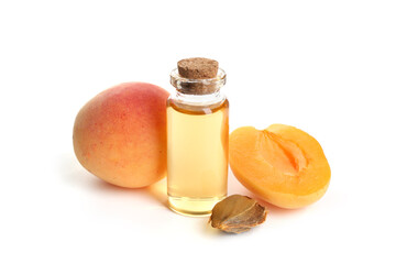 Bottle of essential oil, fresh apricots and kernel isolated on white