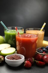 Superfood. Refreshing smoothies in glasses and ingredients on dark table, closeup